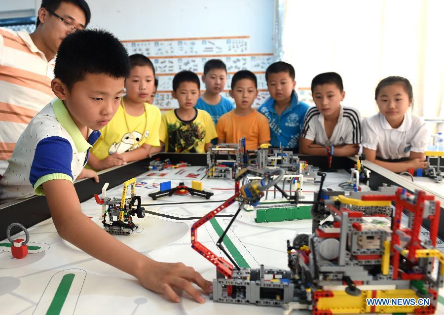 Members of an interest group at Furong primary school test a robot during a summer camp class in Hefei, capital of east China's Anhui Province, July 30, 2015. A robot class held in the Furong primary school of Hefei attracted many students during the summer vacation. (Xinhua/Liu Junxi) 