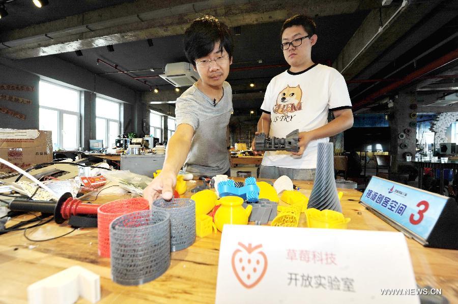 Hou Xiaoye (L) and Gao Hua examine 3D printed models at the the Baidu Pioneer Park in Changchun, capital of northeast China's Jilin Province, July 30, 2015. Graduated from Jilin University, Gao Hua and Hou Xiaoye are both enthusiasts in science and technology. Getting bored with average work, they founded their geek studio which undertakes innovation of gadgets such as 3D printers, drones and wearable virtual reality headsets that they believe can change people's everyday life. (Xinhua/Zhang Nan) 