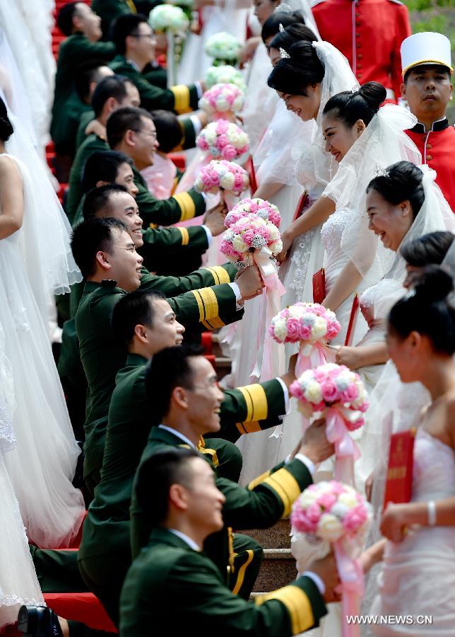 Photo taken on July 31, 2015 shows a group wedding for soldiers in Dongguan City, south China's Guangdong Province. A group wedding was held on Friday for 88 soldiers in Guangdong with the coming of the Army Day and the 88th anniversary of the founding of the Chinese People's Liberation Army, which falls on August 1. (Xinhua/Mao Siqian) 