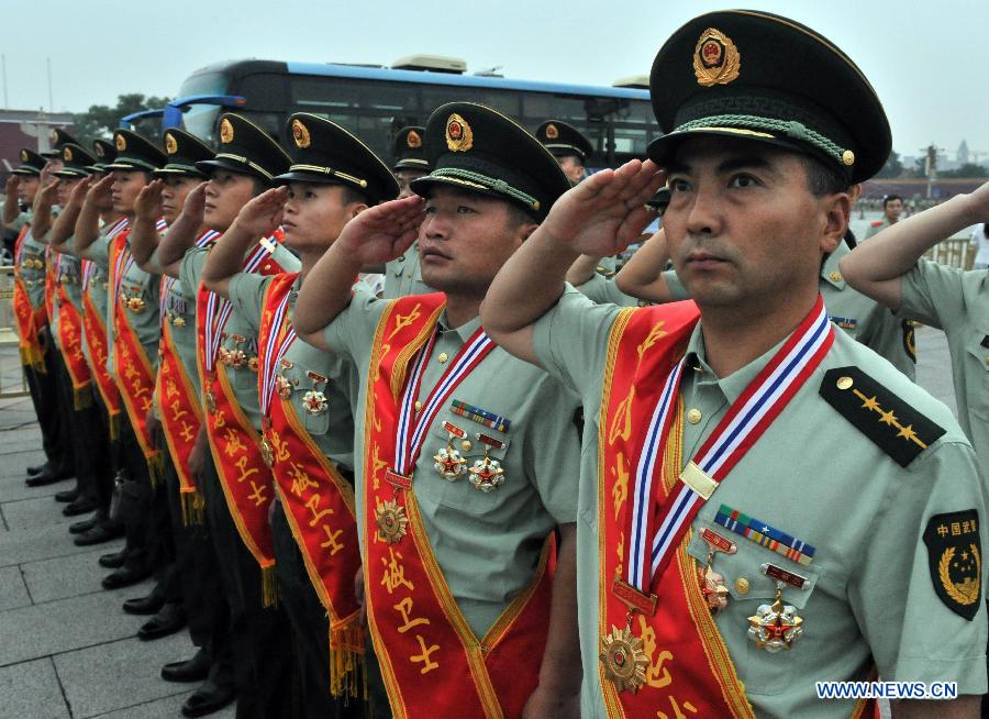 Soldiers salute during a national flag-raising ceremony at the Tian'anmen Square in Beijing, capital of China, Aug. 1, 2015. 