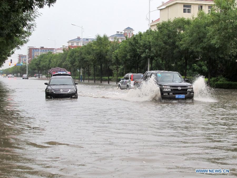 Cars drive in flood water in Wudi County of Binzhou, east China's Shandong Province, Aug. 3, 2015. 