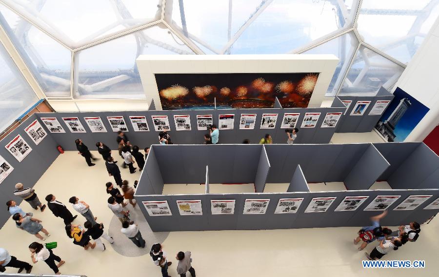 People visit a photo exhibition with the theme of 'Overseas Chinese and the Chinese People's War of Resistance against Japanese Aggression' at National Aquatics Center in Beijing, capital of China, Aug. 4, 2015.