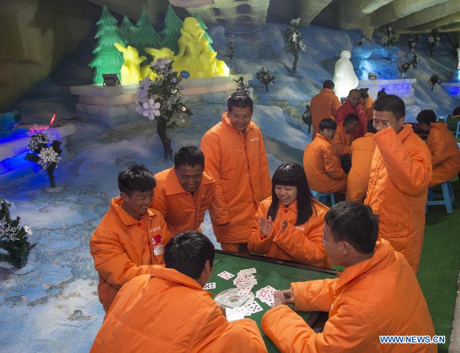 People wearing padded coats play card games in an icehouse at Foreigner's Street in Chongqing, southwest China, Aug. 4, 2015. 