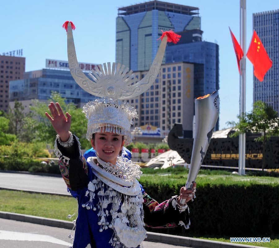 Torch bearer Ma Yanlin of Miao ethnic group runs in the torch relay of the 10th Chinese Traditional Games of Ethnic Minorities in Erdos, Inner Mongolia Autonomous Region, China on Aug. 6, 2015. 