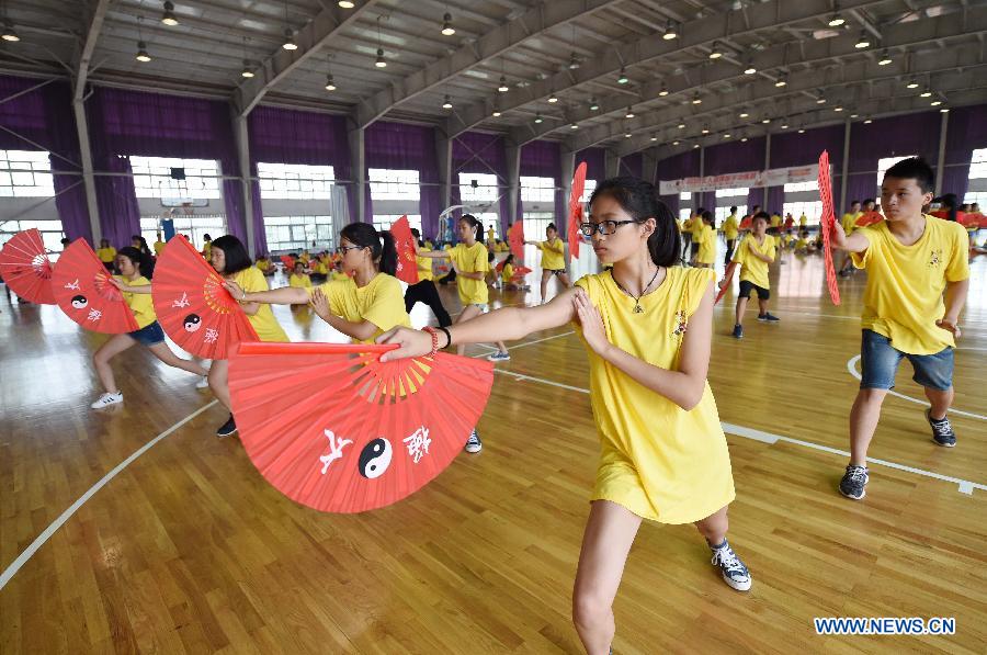 Overseas Chinese youth learn to perform Kung Fu Fan during the 'Chinese Root-Seeking Tour' Summer Camp in Beijing, capital of China, Aug. 7, 2015.