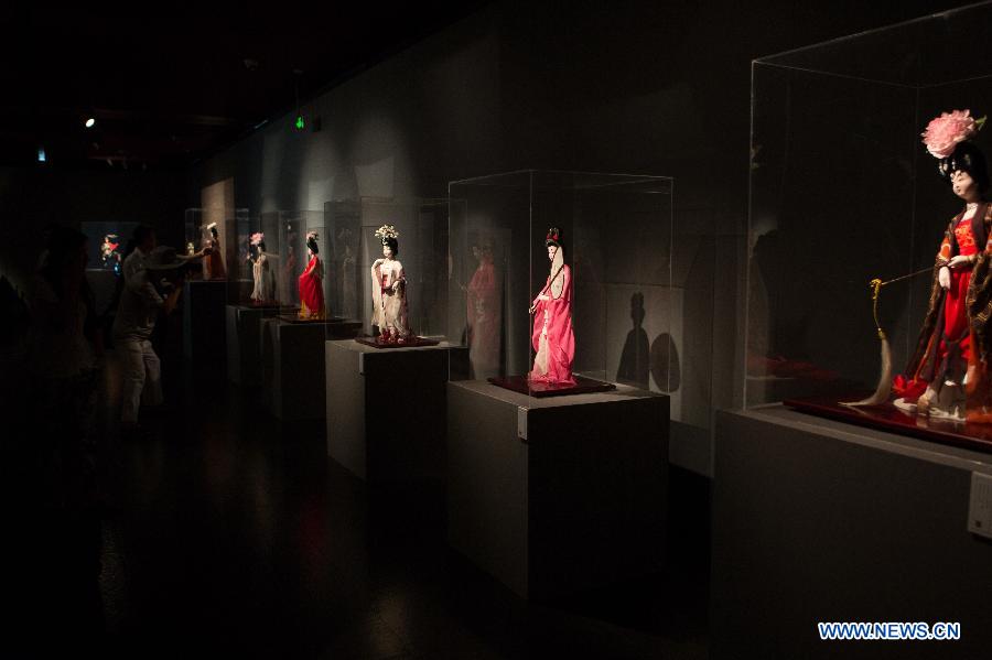 Visitors view silk figurines during an exhibition in Beijing, capital of China, Aug. 7, 2015. 