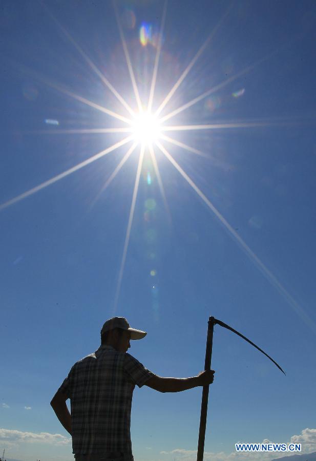 Herdsman prepares to cut grass in Kazak Autonomous County of Barkol, Hami Prefecture, northwest China's Xinjiang Uygur Autonomous Region, Aug. 7, 2015. 