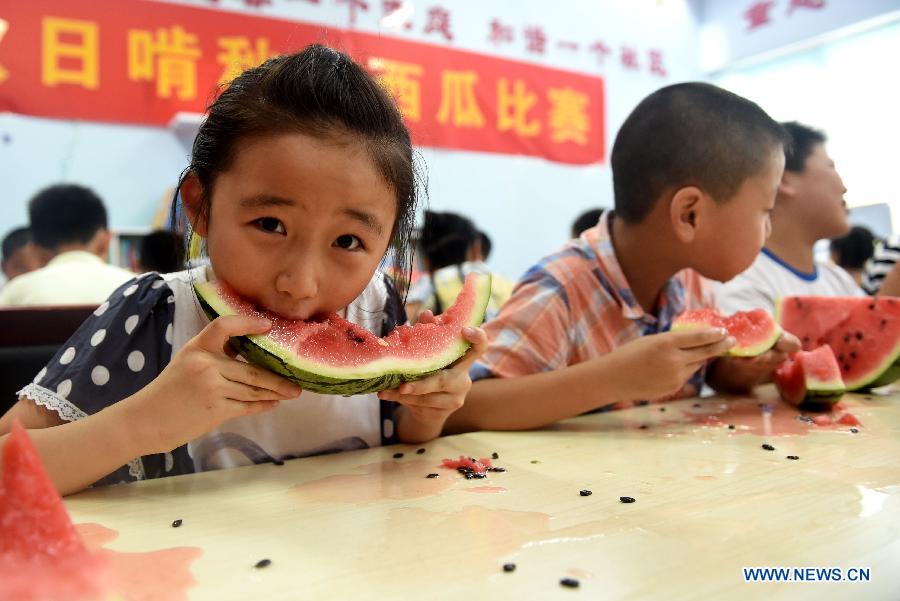 Children eat watermelons to meet the coming solar term 'beginning of autumn' in Hefei, capital of east China's Anhui Province, Aug. 7, 2015. 