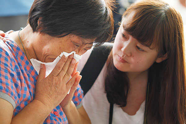 Hao Yuexin, 63, cries after Malaysian Prime Minister Najib Razak announced that experts 'conclusively' confirmed that the debris found on Reunion Island was from MH370. Hao's son, Zhang Jianwu, was onboard the aircraft.[Photo/China Daily]