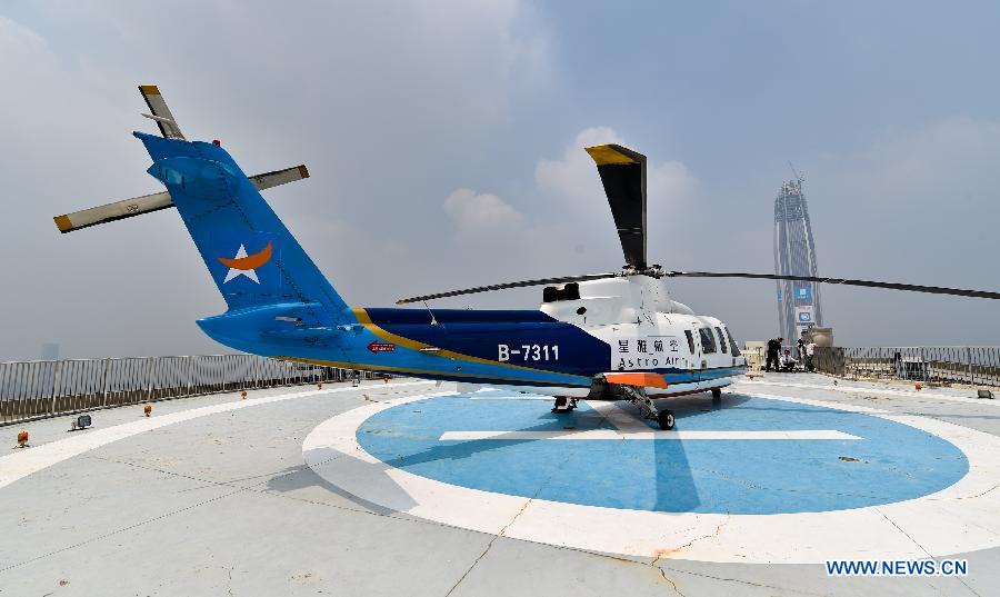 Photo taken on Aug. 7, 2015 shows a helicopter of Astro Air sitting parked on the top of an office building in downtown Shenzhen, south China's Guangdong Province. 