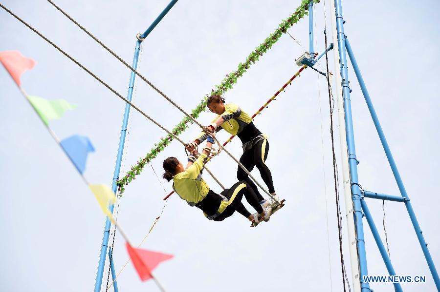 Athletes Wu Anzhen (R) and Fei Qianhong from central China's Hunan Province compete in a doule game of swing during the 10th National Traditional Games of Ethnic Minorities of China in Ordos, north China's Inner Mongolia Autonomous Region, Aug. 10, 2015. 