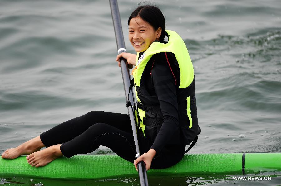 Athlete Shi Hui from east China's Jiangsu Province smiles after a match of single bamboo drifting, a specialty originated from southwest China's Guizhou Province, during the 10th National Traditional Games of Ethnic Minorities of China in Ordos, north China's Inner Mongolia Autonomous Region, Aug. 10, 2015.