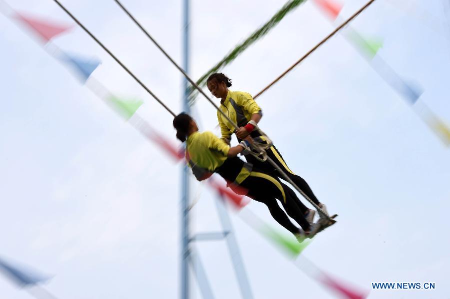 Athletes Wu Anzhen (R) and Fei Qianhong from central China's Hunan Province compete in a doule game of swing during the 10th National Traditional Games of Ethnic Minorities of China in Ordos, north China's Inner Mongolia Autonomous Region, Aug. 10, 2015. 