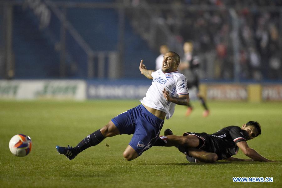 Nacional's Damian Eroza (L) vies the ball with Villa Teresa's Diego Martinones (R) during their match on day 1 of the Opening Tournament of the Uruguyan Soccer Championship, held in the Gran Parque Central stadium, in Montevideo, capital of Uruguay, on Aug. 15, 2015.