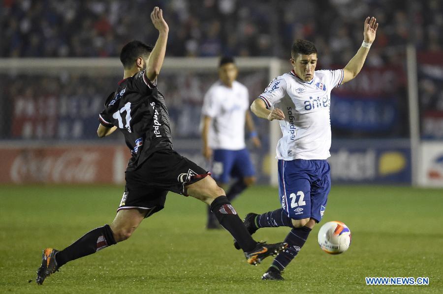 Nacional's Alfonso Espino (R) vies the ball with Villa Teresa's Gabriel De Leon (L) during their match on day 1 of the Opening Tournament of the Uruguyan Soccer Championship, held in the Gran Parque Central stadium, in Montevideo, capital of Uruguay, on Aug. 15, 2015. 