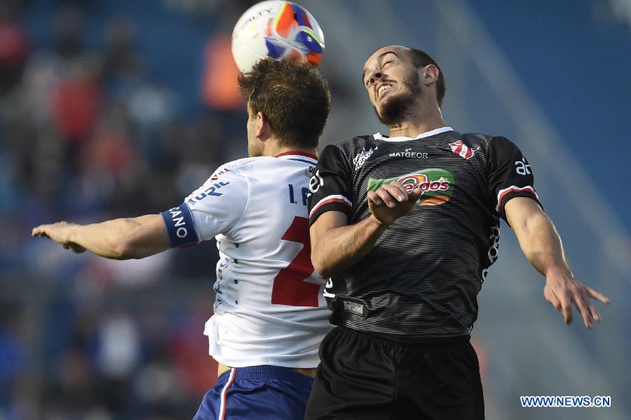 Nacional's Ivan Alonso (L) vies the ball with Villa Teresa's Jonathan Souza Motta (R) during their match on day 1 of the Opening Tournament of the Uruguyan Soccer Championship, held in the Gran Parque Central stadium, in Montevideo, capital of Uruguay, on Aug. 15, 2015. 