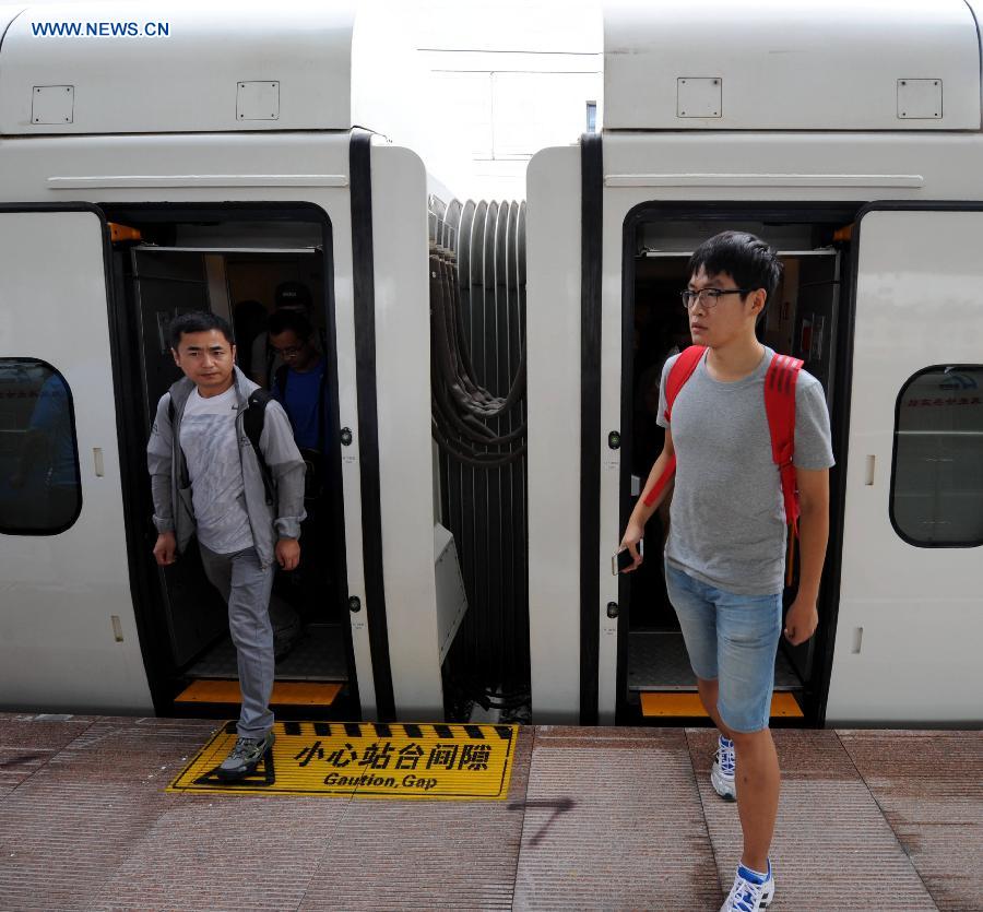 Passengers get off the train at the Daqing West Railway Station in Daqing, northeast China's Heilongjiang Province, Aug. 17, 2015. 