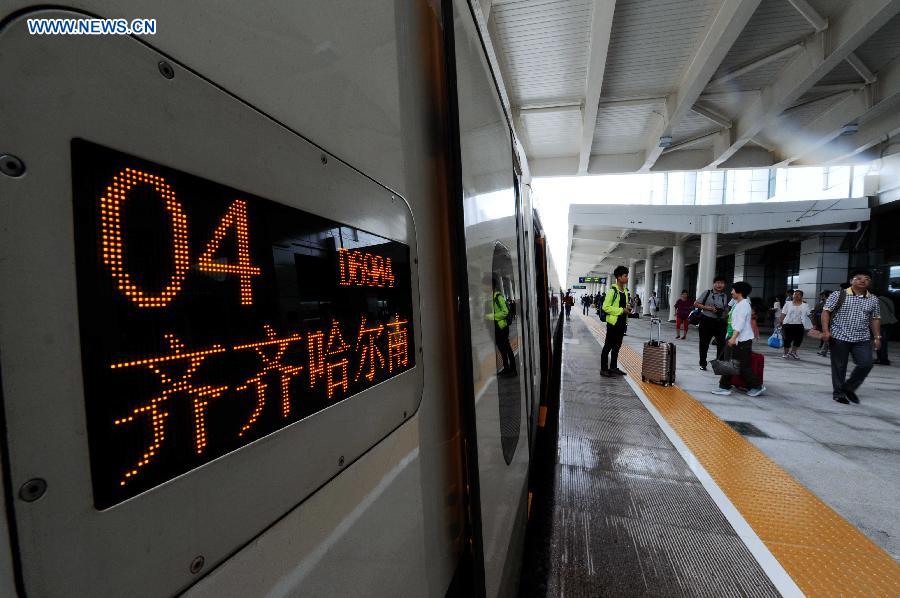 Passengers wait to board the train at the Qiqihar South Railway Station, northeast China's Heilongjiang Province, Aug. 17, 2015. 