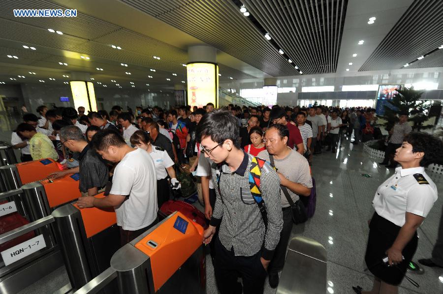 Passengers queue to enter the Qiqihar South Railway Station in Qiqihar, northeast China's Heilongjiang Province, Aug. 17, 2015.