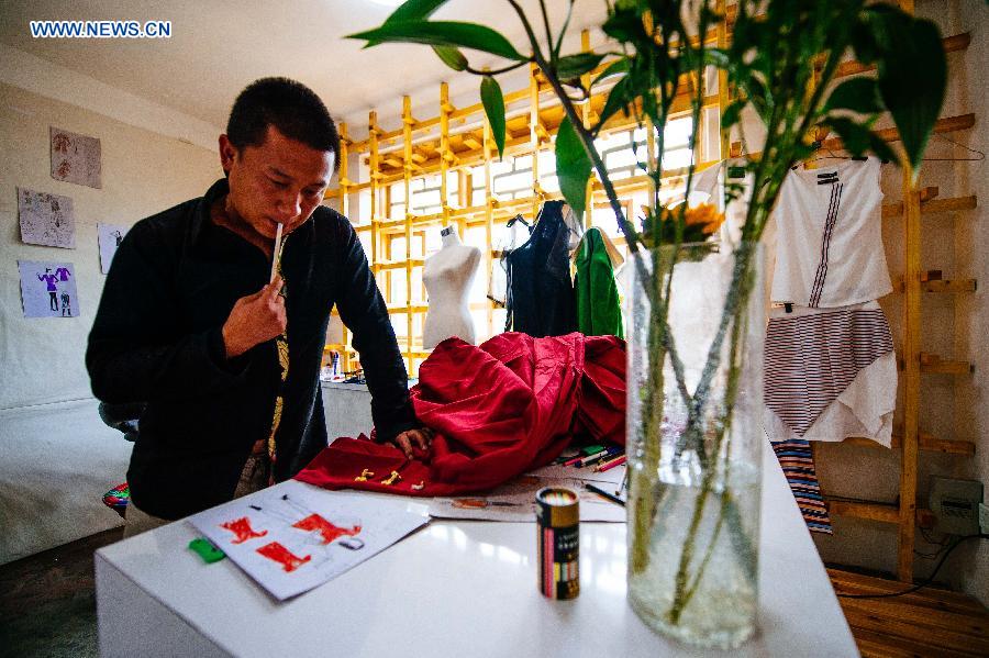 Genqoi Tashi revises his design sketch in his workshop in Lhasa, capital of southwest China's Tibet Autonomous Region, Aug. 12, 2015. 