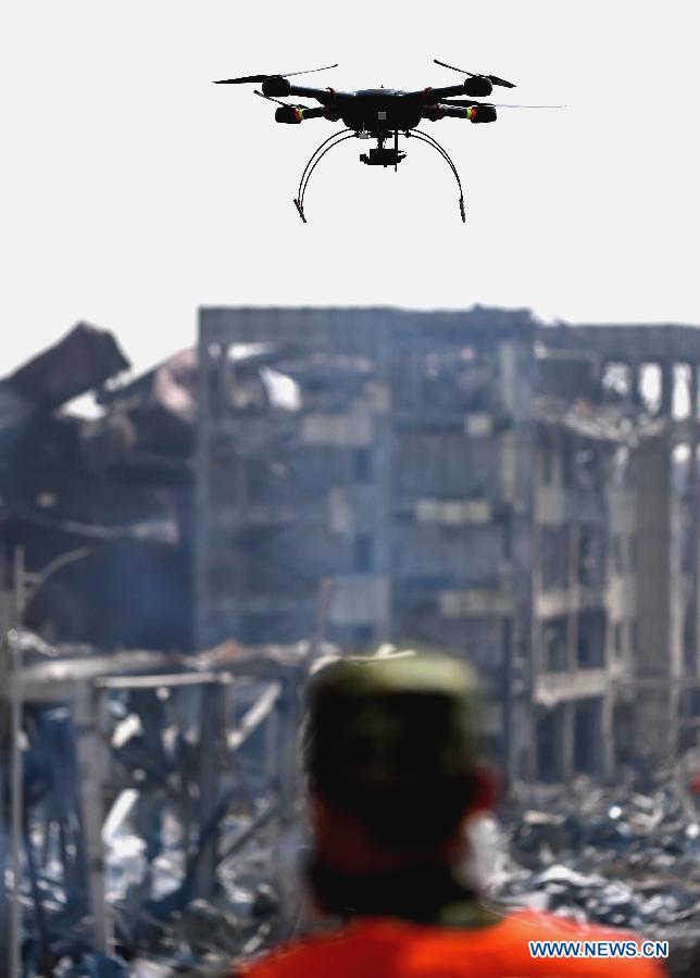 A rescuer using a drone detects the core blast site in Tianjin, north China, Aug. 22, 2015.