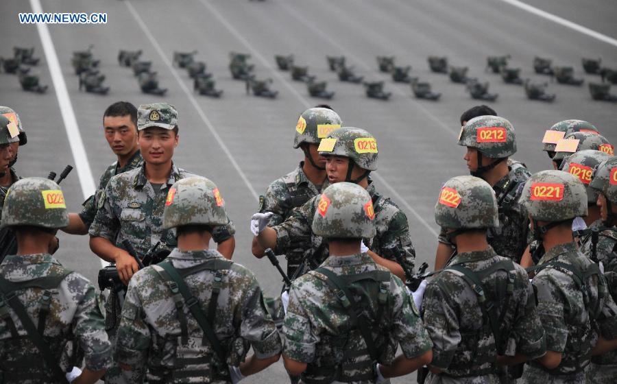 Photo taken on July 28, 2015 shows soldiers communicate with each other during training for the Sept. 3 military parade at the parade training base in Beijing. 