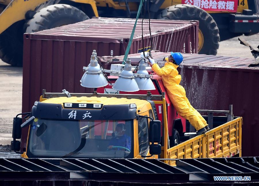 A rescuer transports lighting facility to the core area of explosion site in Tianjin, north China, Aug. 25, 2015.