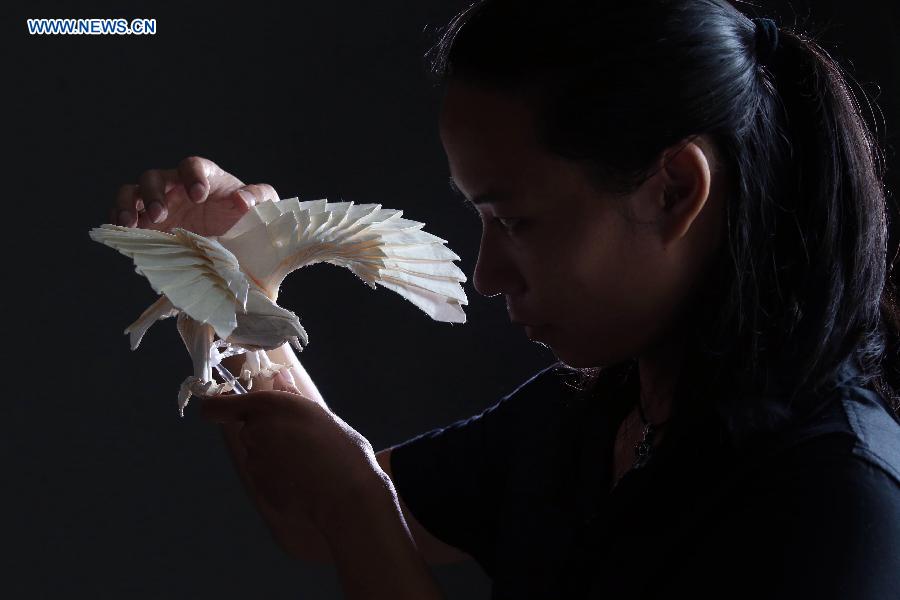 Qin Kun shows his origami works in the pattern of eagle in Guilin, south China's Guangxi Zhuang Autonomous Region, Sept. 6, 2015. 