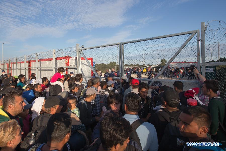 Illegal migrants wait to enter a newly built migrant camp near Roszke, a village on the Serbian-Hungarian border, Hungary, on Sept. 7, 2015.