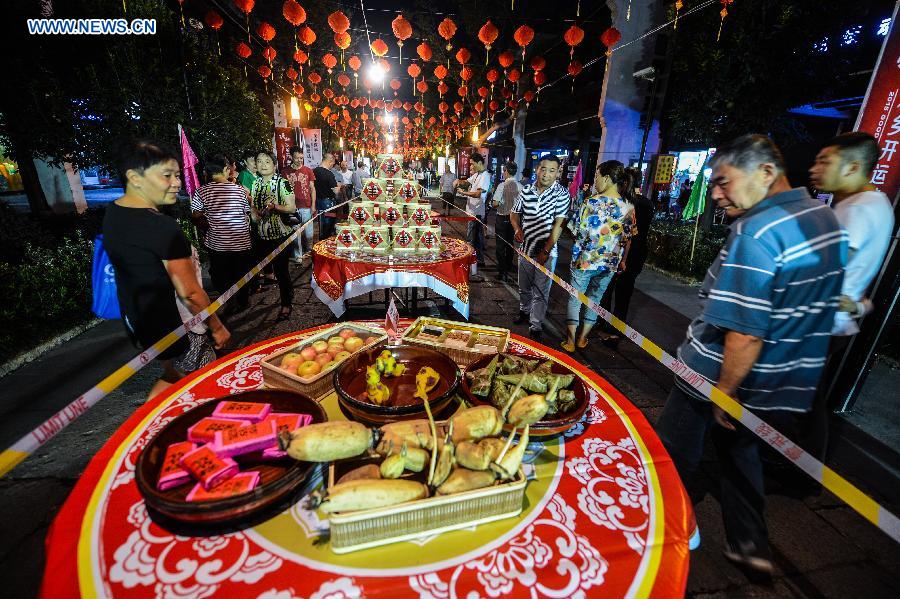 Local residents arrange a street-long banquet, presenting traditional pastries and dishes, to celebrate the coming Mid-Autumn Festival in Tangxi Town of Hangzhou, east China's Zhejiang Province, Sept. 24, 2015. 