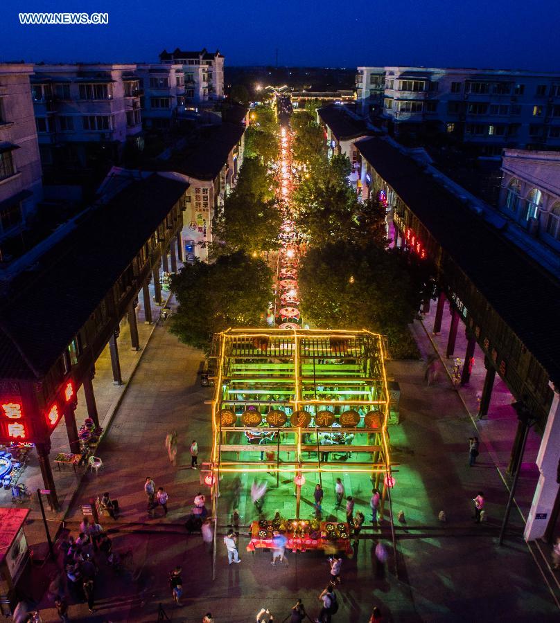 Local residents arrange a street-long banquet, presenting traditional pastries and dishes, to celebrate the coming Mid-Autumn Festival in Tangxi Town of Hangzhou, east China's Zhejiang Province, Sept. 24, 2015.