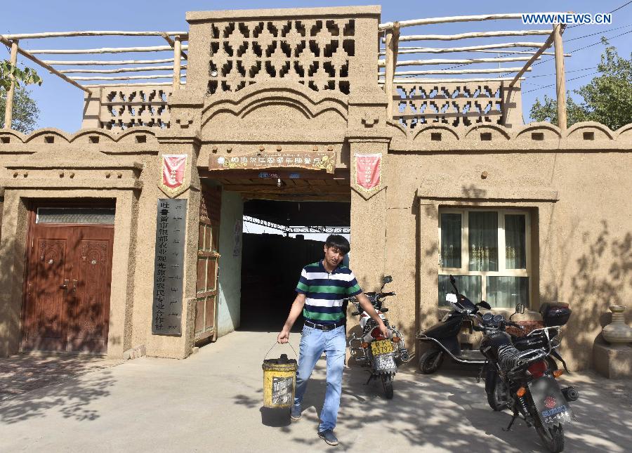 Pataer Keyimu walks out of his home in the Grape Valley of Turpan, northwest China's Xinjiang Uygur Autonomous Region, Sept. 6, 2015. 