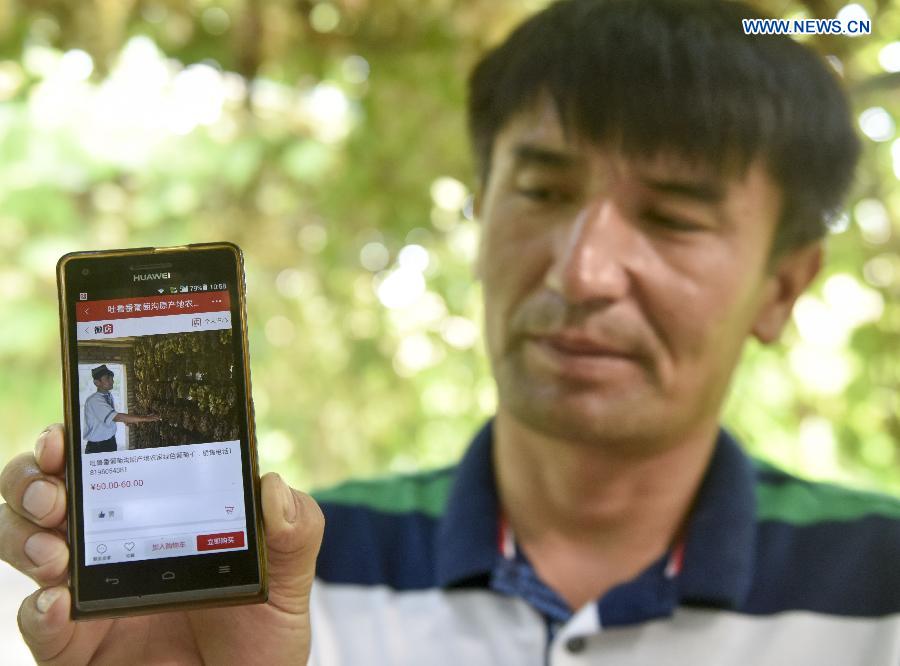 Pataer Keyimu shows his online shop at home in the Grape Valley of Turpan, northwest China's Xinjiang Uygur Autonomous Region, Sept. 7, 2015. 