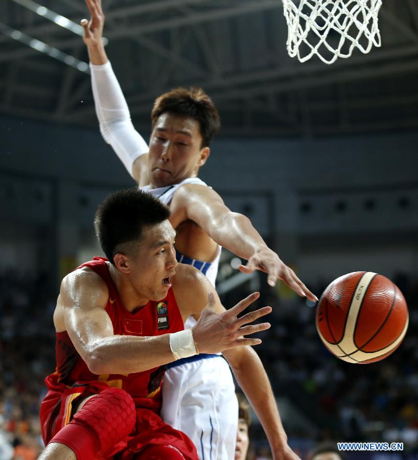 Guo Ailun (L) of China passes the ball during the preliminary round Group C match against South Korea at 2015 FIBA Asia Championship in Changsha, capital of central China's Hunan Province, Sept. 24, 2015. 