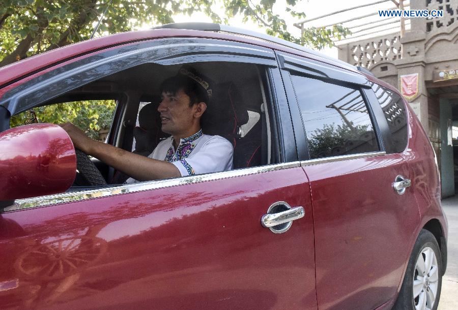 Pataer Keyimu drives his car in the Grape Valley of Turpan, northwest China's Xinjiang Uygur Autonomous Region, Sept. 6, 2015.