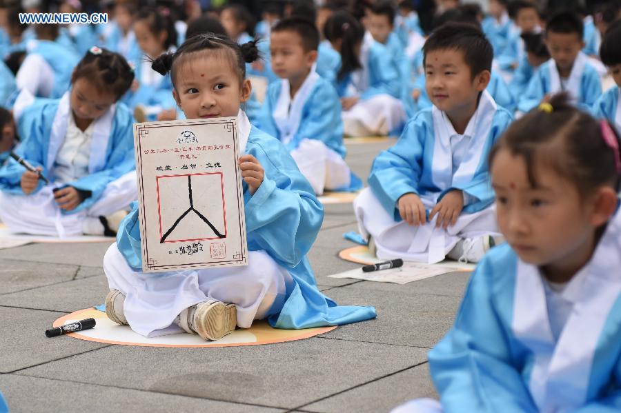 A girl shows a Chinese character during a first writing ceremony in Guiyang, capital of southwest China's Guizhou Province, Sept. 28, 2015.