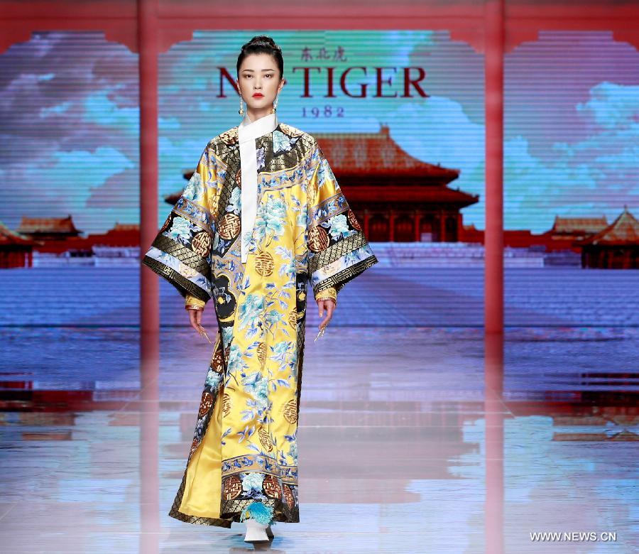 Models present creations by NE TIGER Haute Couture 2015 collection with the theme 'Qipao' during the opening show for the China Fashion Week in Beijing, capital of China, Oct. 25, 2015.