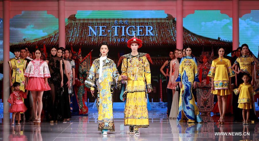 Models present creations by NE TIGER Haute Couture 2015 collection with the theme 'Qipao' during the opening show for the China Fashion Week in Beijing, capital of China, Oct. 25, 2015.