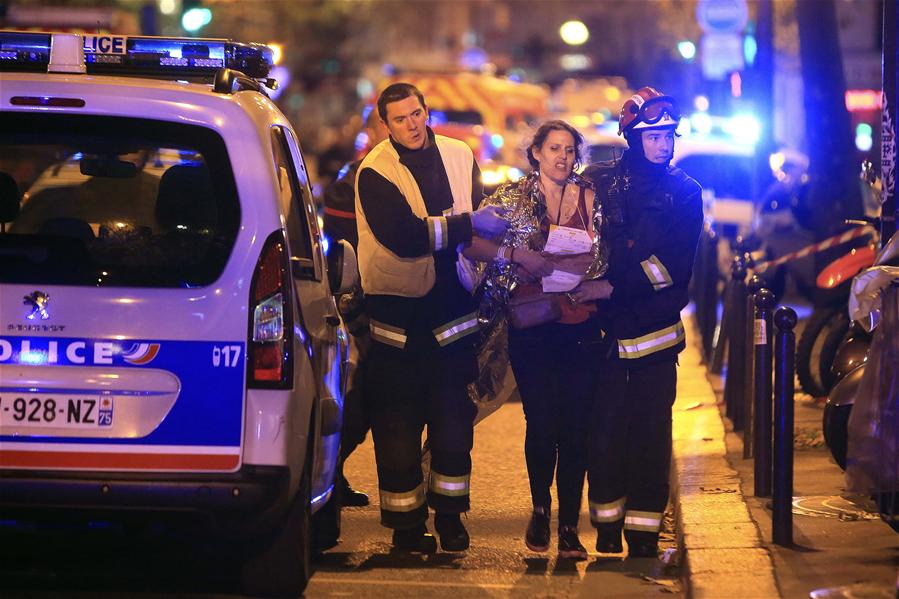 Wounded people are evacuated outside the scene of a hostage situation at the Bataclan theatre in Paris, 13 November 2015.