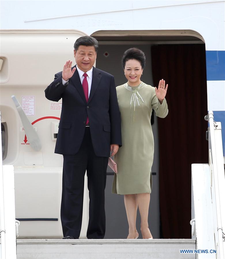 Chinese President Xi Jinping (L) and his wife Peng Liyuan wave upon their arrival in Pretoria, South Africa, Dec. 2, 2015. 