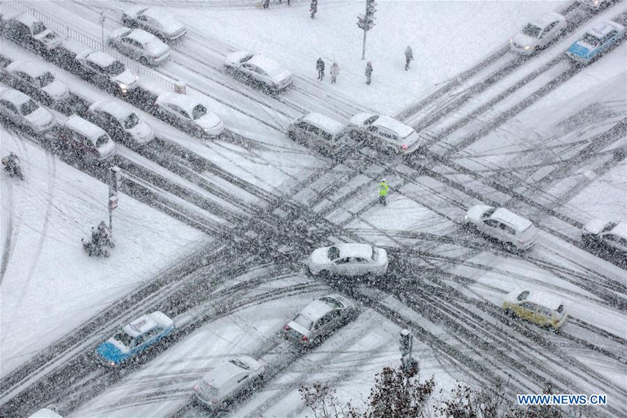 Vehicles run slowly in heavy snow at a crossing in Weihai, a coastal city of east China's Shandong Province, Dec. 16, 2015. 