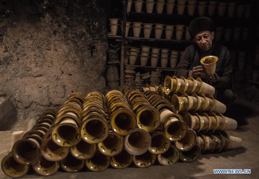 A local handicraftsman arranges clay potteries at his home studio in the old town of Kashgar, northwest China's Xinjiang Uygur Autonomous Region, Dec. 19, 2015.