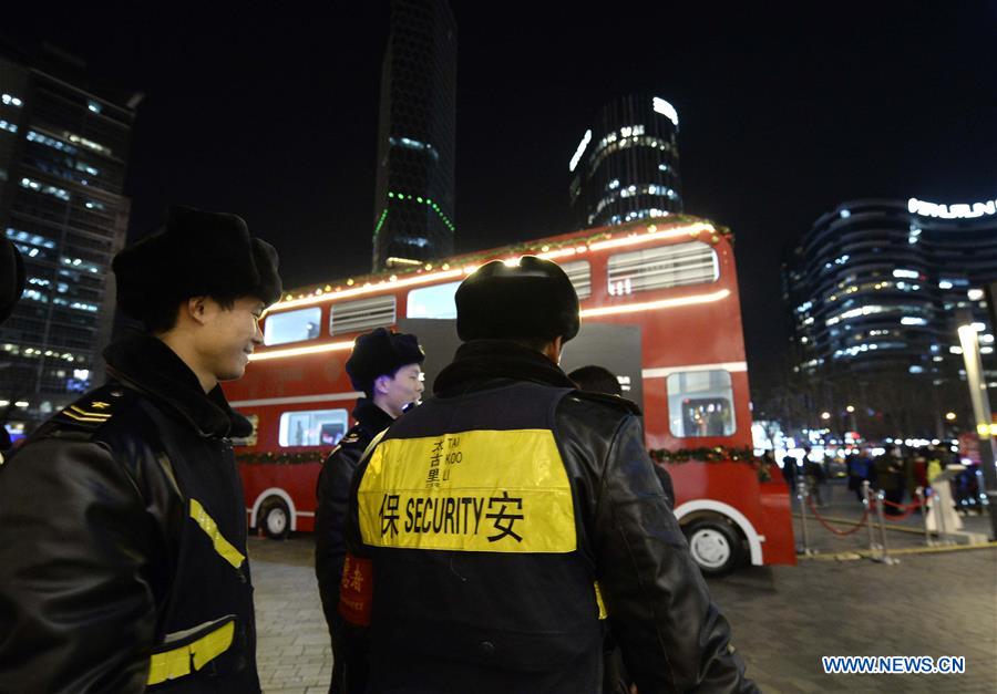 Scurity personnel patrol the popular Sanlitun area in Beijing, capital of China, Dec. 24, 2015. 