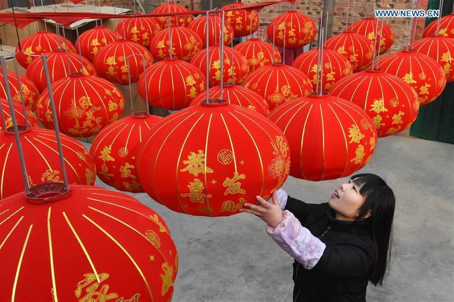 A villager dries newly-made red lanterns in Shijing Village of Wuzhi County, central China's Henan Province, Jan. 12, 2016.