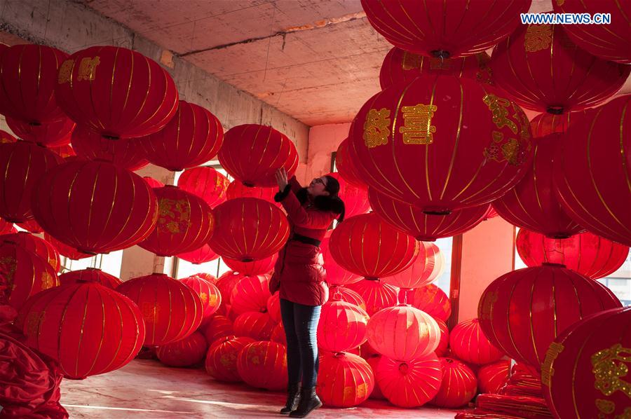 A worker hangs red lanterns in Tuntou Village, Gaocheng District, Shijiazhuang City, north China's Hebei Province, Jan. 13, 2016.