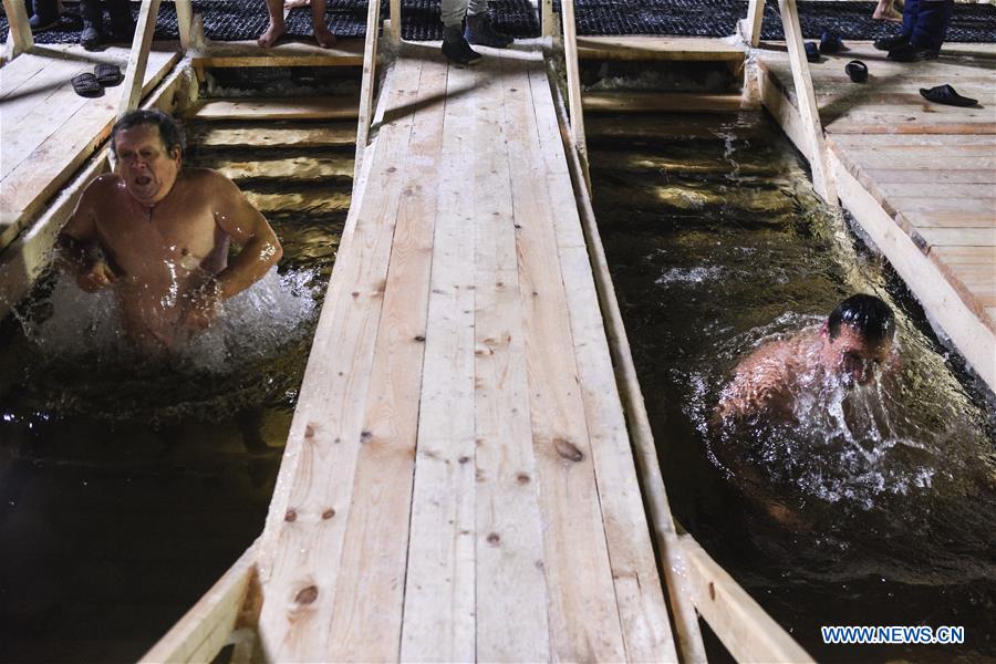 VALDAY, Jan. 19, 2016 (Xinhua) -- Russian Orthodox believers bathe in the icy water on Epiphany in Valday lake near Iversky monastery with the air temperature at about 10 Celsius degrees below zero, in Valday, Russia, Jan. 19, 2016. Orthodox believers mark Epiphany on Jan. 19 by immersing themselves in icy waters regardless of the weather. The water is blessed by a cleric and considered pure. (Xinhua/Evgeny Sinitsyn) 