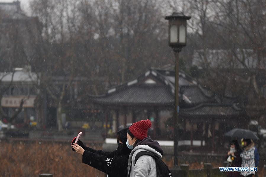 Tourists appreciate the beautiful view, in spite of freezing cold air, in West Lake Resort Area on Jan. 21, 2016 in Hangzhou, capital of east China's Zhejiang Province. 