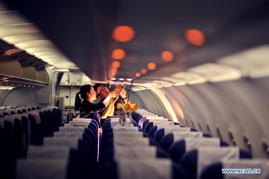 Staff members check oxygen masks inside a cabin at the maintenance base of China Southern Airlines in Haikou, capital of south China's Hainan Province, on Jan. 21, 2016. 