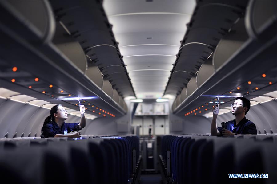 Staff members check the equipments inside a cabin at the maintenance base of China Southern Airlines in Haikou, capital of south China's Hainan Province, on Jan. 21, 2016. 