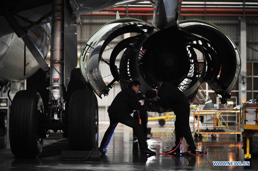 Mechanics check an aircraft engine at the maintenance base of China Southern Airlines in Haikou, capital of south China's Hainan Province, on Jan. 21, 2016.